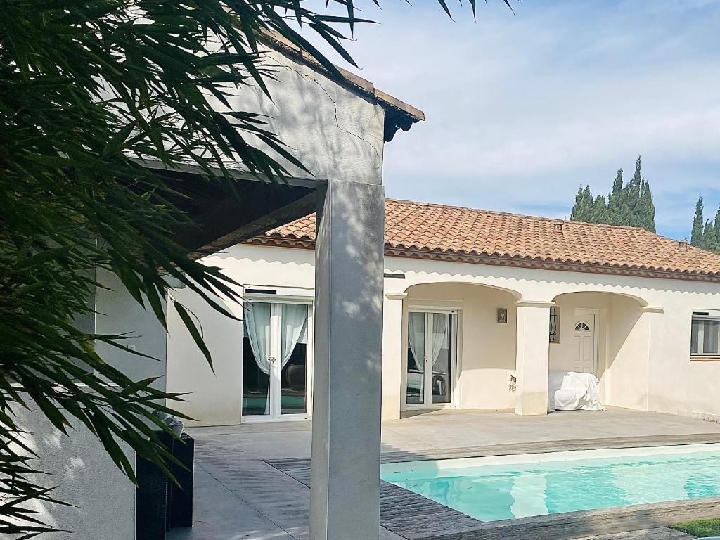 uma casa com uma piscina em frente em Villa Jurio em Argeliers