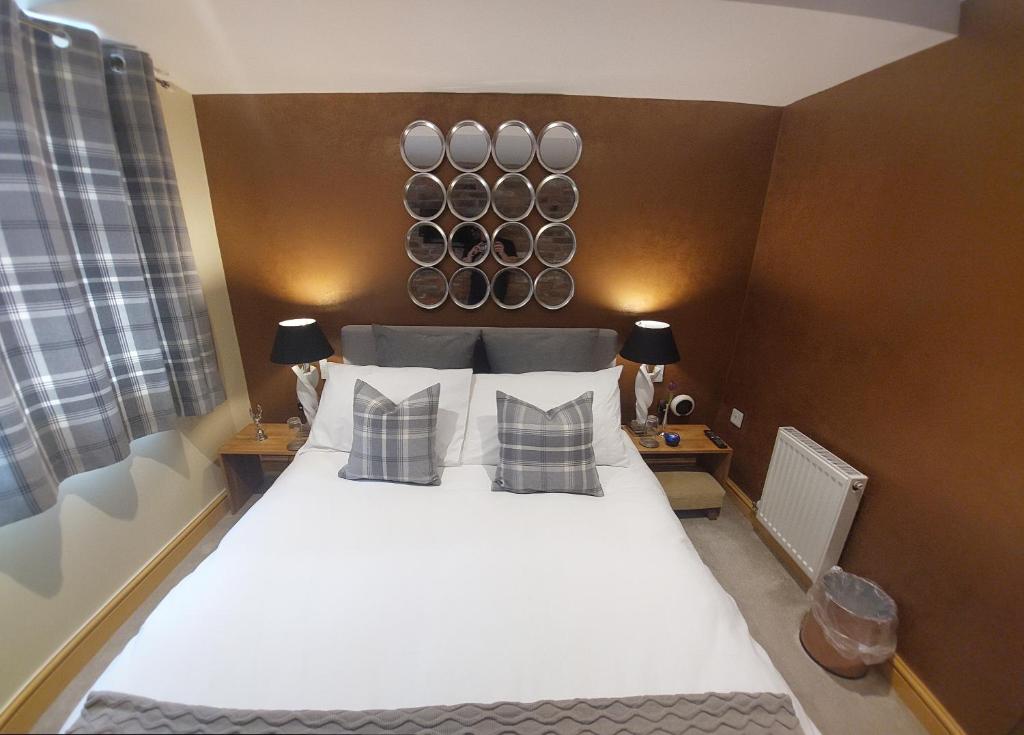 ein Schlafzimmer mit einem großen weißen Bett mit Kissen in der Unterkunft The Mews in Alderley Edge