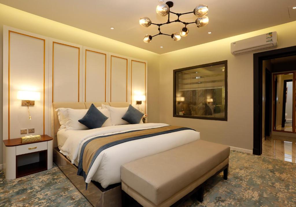 sypialnia z dużym łóżkiem i żyrandolem w obiekcie وايت مون للاجنحة الفندقية الضيافة w mieście Chamis Muszajt