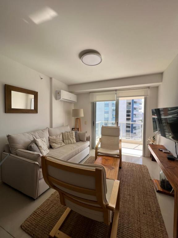 ein Wohnzimmer mit einem Sofa und einem Tisch in der Unterkunft Apartamento en Arenas del Mar, Punta del Este in Punta del Este