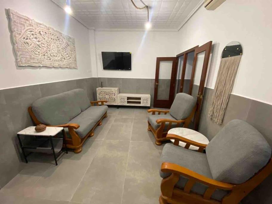una sala de espera con 2 sillas y TV en La Casita Burriana en Burriana