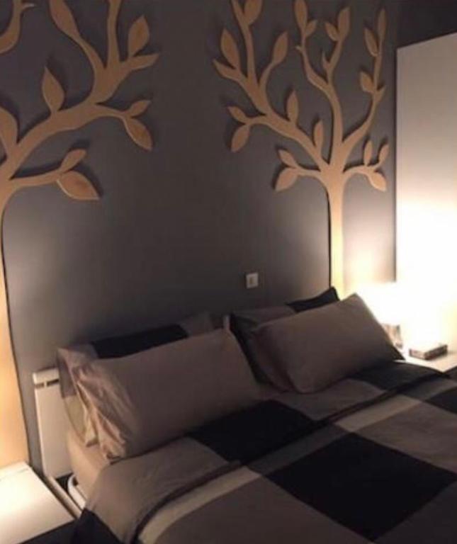a bedroom with a bed with trees on the wall at Appartamento a due passi dal centro in Pavia