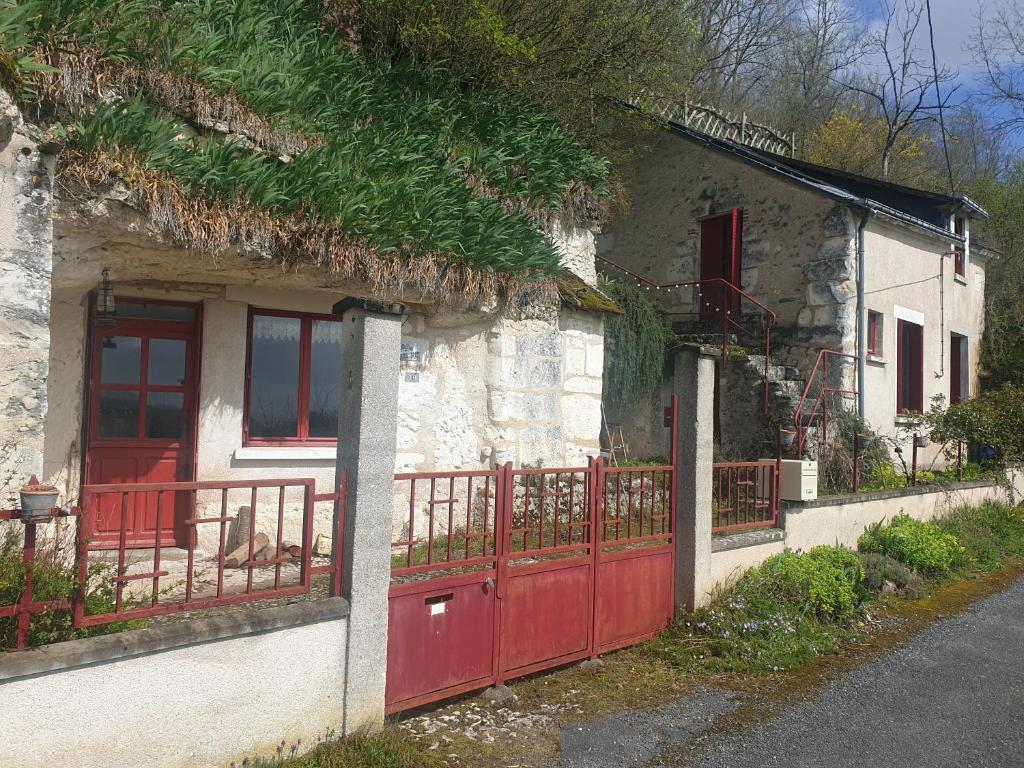 dom z czerwonymi drzwiami i czerwonym płotem w obiekcie Gite troglodyte Les Iris w mieście Villiers-sur-Loir