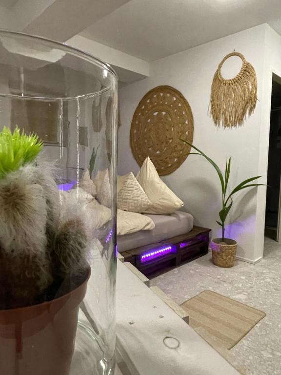 a living room with a bed and a vase with plants at Apartment im BOHO Stil nähe Salzburg in Freilassing