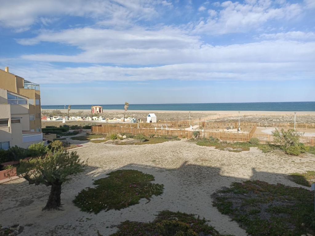 um pátio com vista para a praia e um edifício em Studio Vue Mer 100 m de la plage em Port Leucate