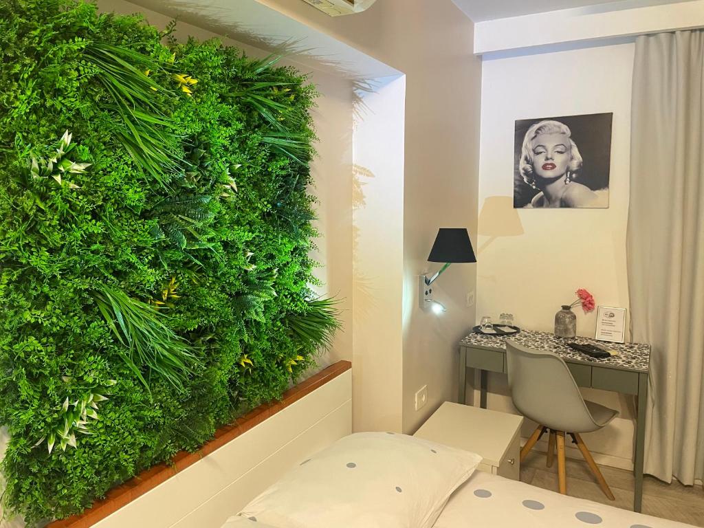 a living wall in a room with a chair and a desk at Hostel Pipištrelo in Pula