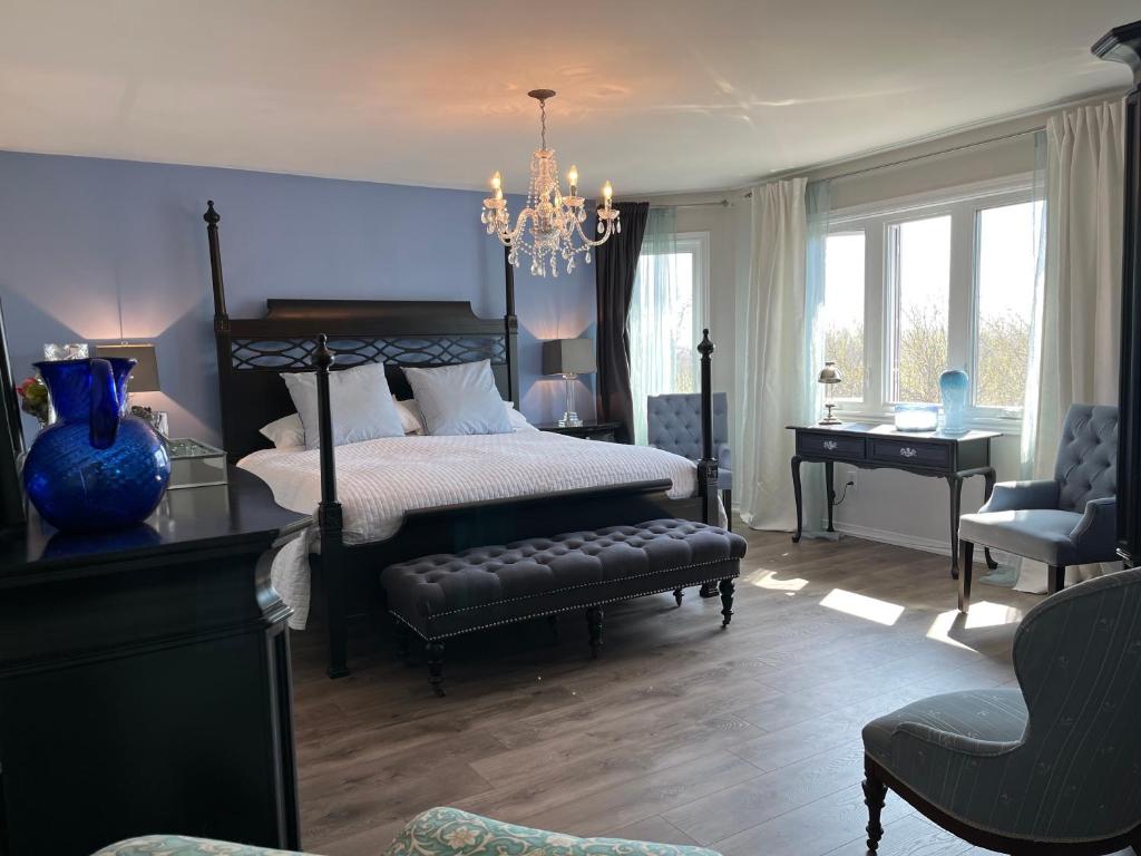 een slaapkamer met een bed, een bureau en een stoel bij Lulu's Bed & Breakfast in Niagara on the Lake