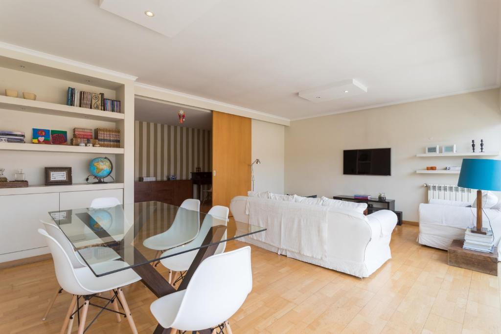 リスボンにあるFLH Alcântara Family Apartmentのリビングルーム(ガラステーブル、白い椅子付)
