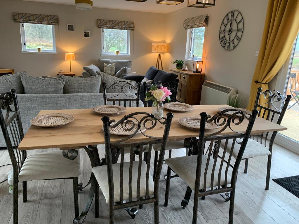 uma sala de jantar com uma mesa de madeira e cadeiras em Birchwood View em Aboyne