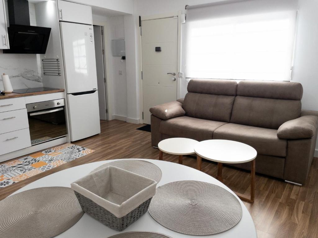 ein Wohnzimmer mit einem Sofa und einem Tisch in der Unterkunft Apartamento de Julia in Córdoba