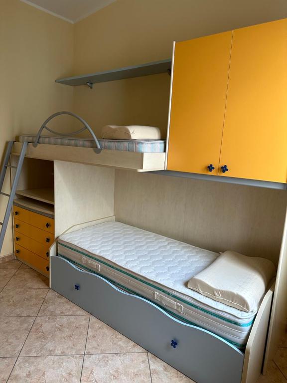 two bunk beds in a room with yellow cabinets at Appartamenti Estivi in Cirò Marina