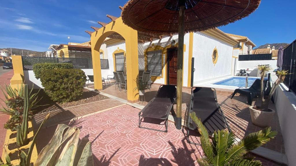 a house with a patio and an umbrella at Casa Naranja in Mazarrón