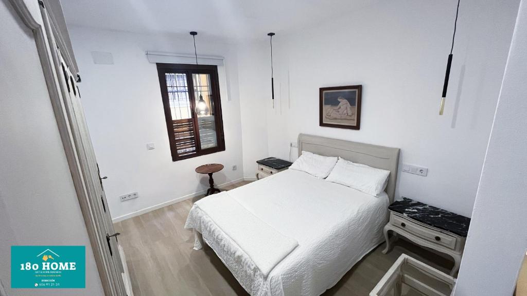 - une chambre blanche avec un lit et une fenêtre dans l'établissement 180 home Luxury Redes, à Séville