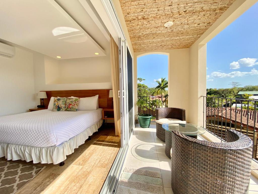 a bedroom with a bed and a balcony at Tropical Luxury 2Bdr condo - Pool view - At the Beach in Tamarindo