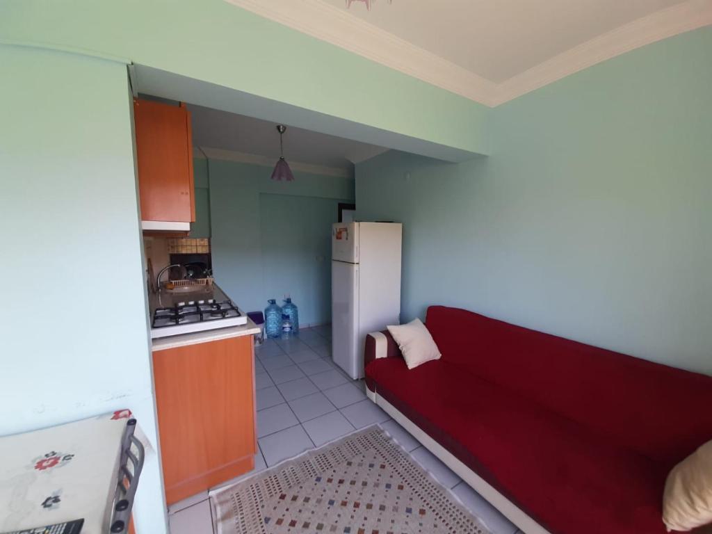 uma cozinha com um sofá vermelho num quarto em KESKINEL apart daire em Amasra