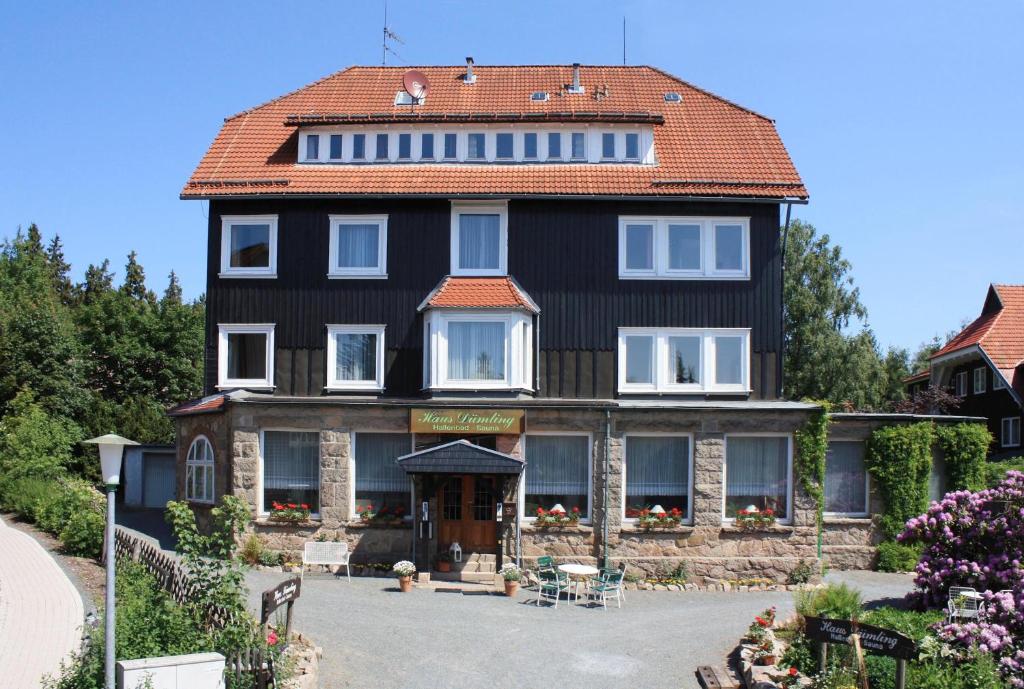 une grande maison noire avec un toit rouge dans l'établissement Haus Dümling, à Braunlage