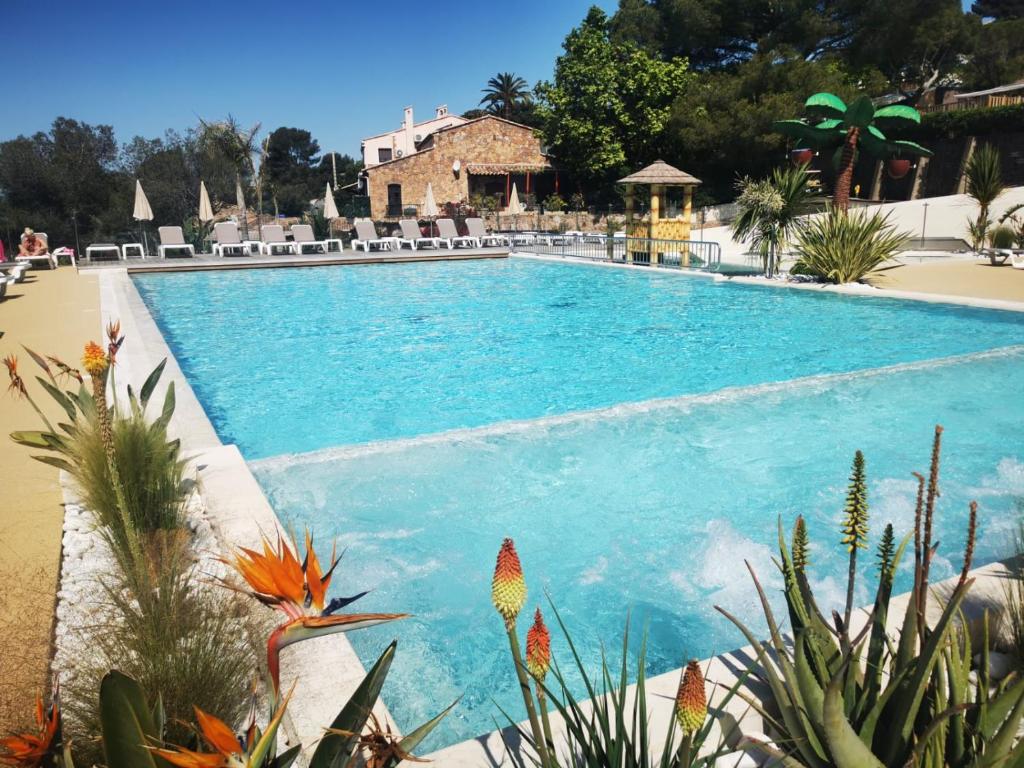 una piscina de agua azul en un complejo en Mobil home neuf camping l ile dor plage st raphael avec piscine, en Saint-Raphaël