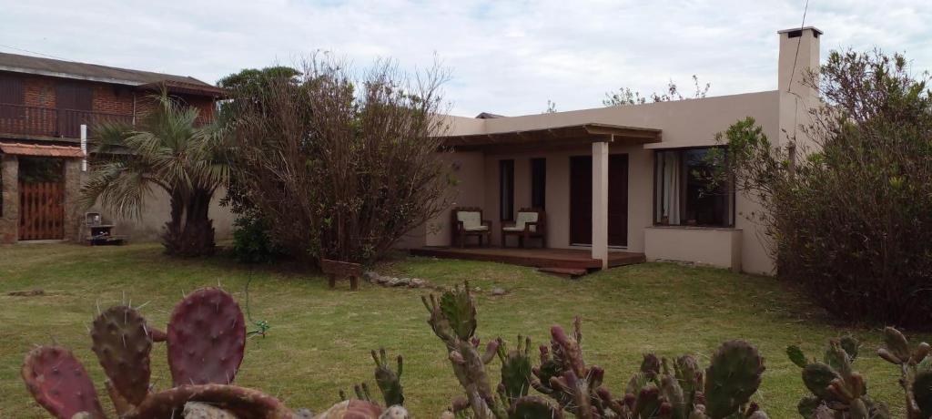 una casa con un jardín delante de ella en Casas de la Paloma - BUTIA en La Paloma