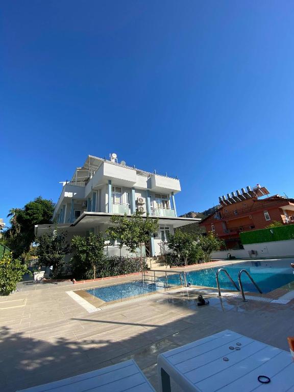 a building with a swimming pool next to a house at Villa Maleyna in Kemer