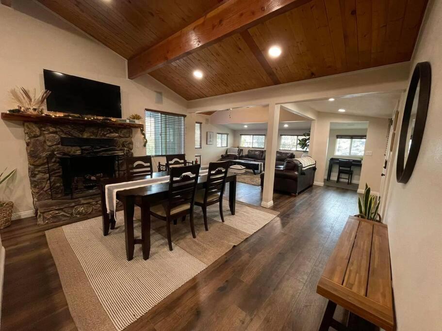 a living room with a dining table and a fireplace at Modern hilltop cabin, 3 miles from Snow Valley in Arrowbear Lake