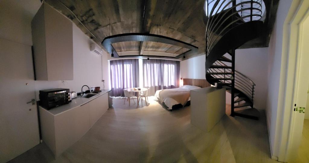 um quarto com uma cama e uma escada em espiral em La Belle San Isidro Lofts - Loft Violetas em San Isidro