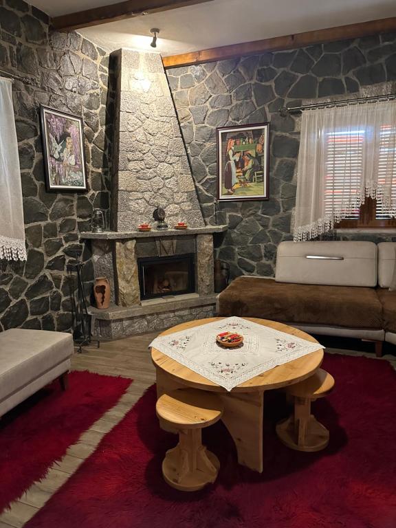 salon ze stołem i kominkiem w obiekcie The Village House w mieście Korcza
