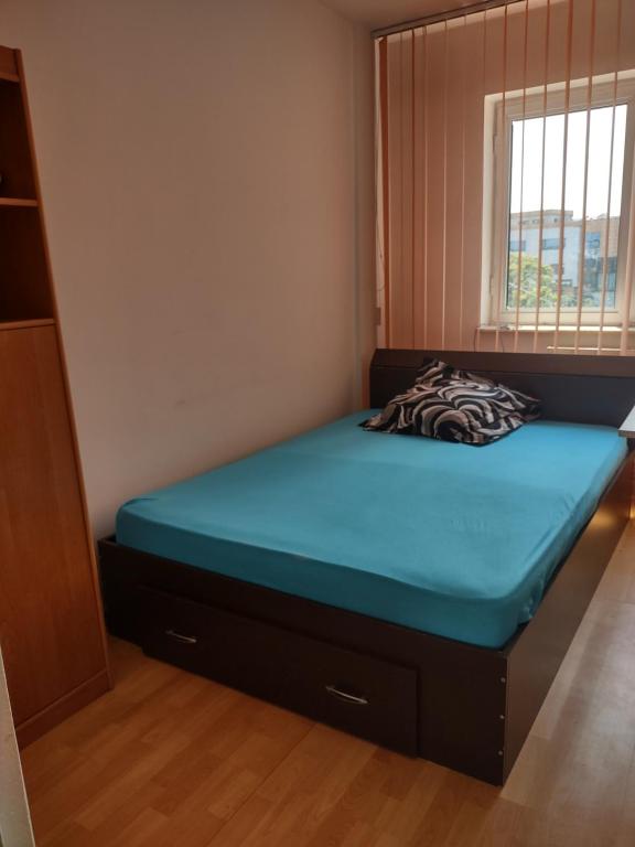 een slaapkamer met een bed met een blauwe matras bij Spacious 4 rooms downtown apartment in Pitesti in Piteşti