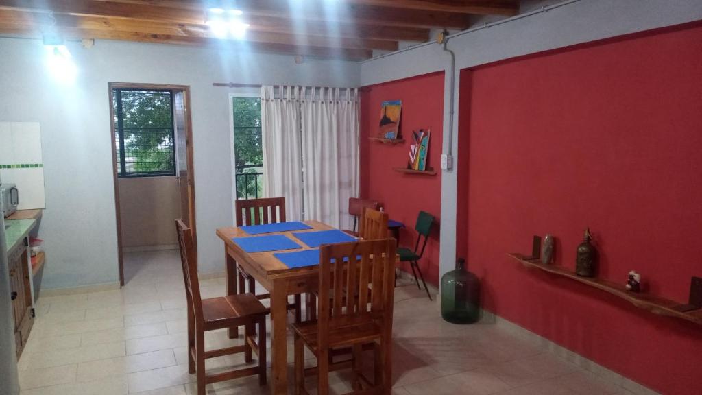 a dining room with a table and a red wall at Lo de la Abuela in Goya