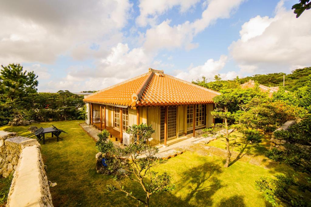 uma pequena casa amarela com um telhado laranja em かたあきの里 em Ilhas Miyako