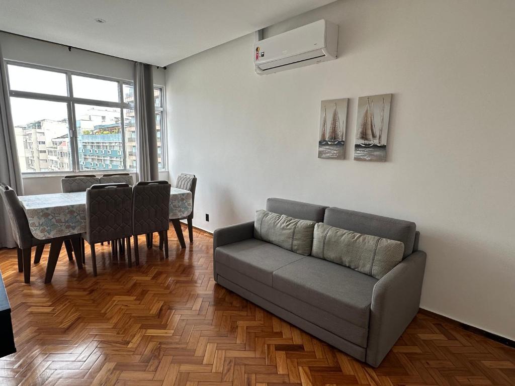 a living room with a couch and a table at Belíssimo apartamento com vista para a praia de Copacabana e cristo in Rio de Janeiro