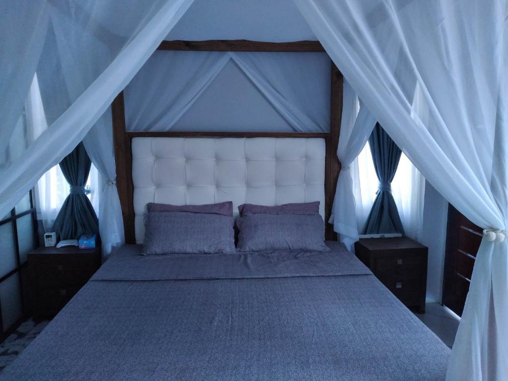 a bedroom with a large bed with a white canopy at Rowena's River Resort 