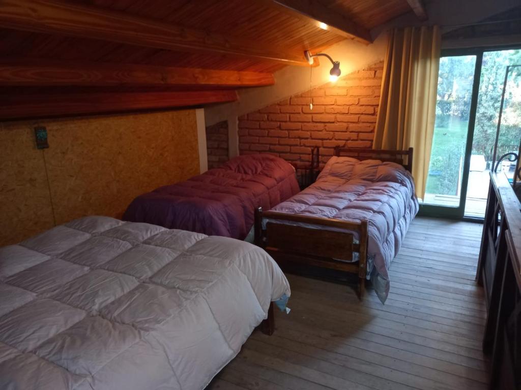 1 Schlafzimmer mit 3 Betten in einem Zimmer in der Unterkunft Cabaña Pedemonte in Vistalba