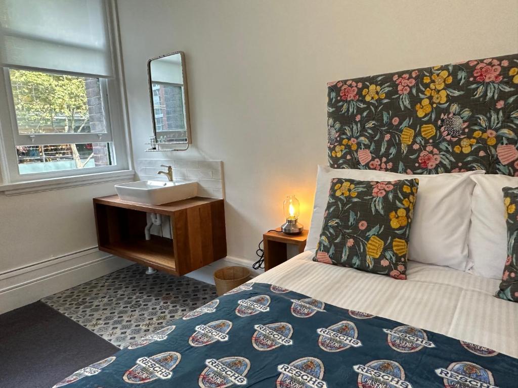 1 dormitorio con cama, lavabo y espejo en The Resch House en Sídney