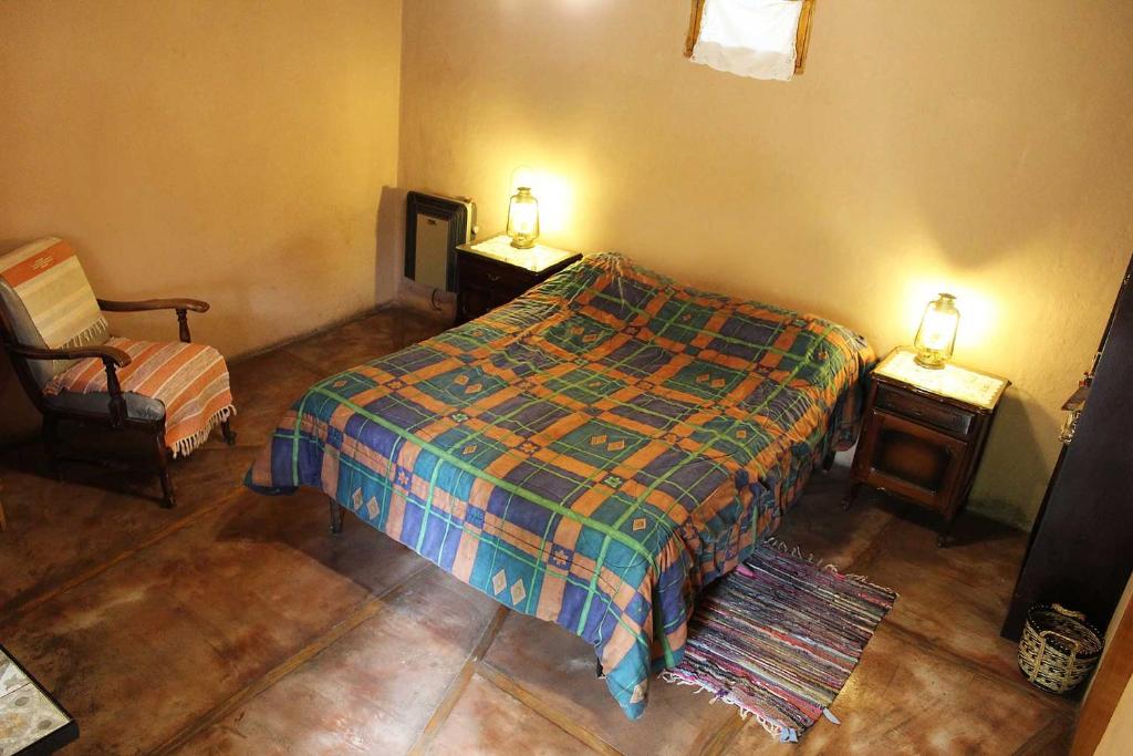 a bedroom with a bed and a chair and a tv at Tomillo Alojamiento Unidad 1 Bed and Breakfast Habitación con baño SIN COCINA in Potrerillos