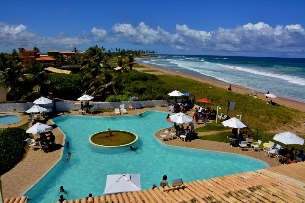an overhead view of a swimming pool next to a beach at OYO Hotel Arembepe Beach Hotel, Camacari in Arembepe