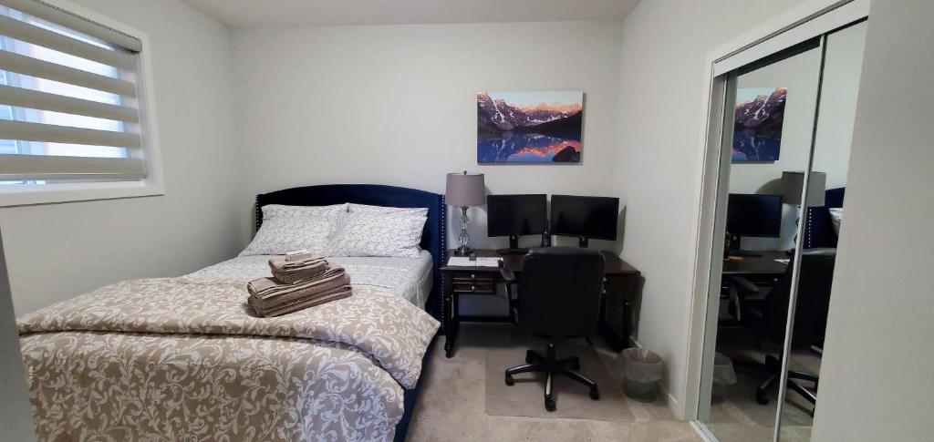 um quarto com uma cama e uma secretária com um computador em Delightful 1-bedroom Private Suite in a New Home em Calgary
