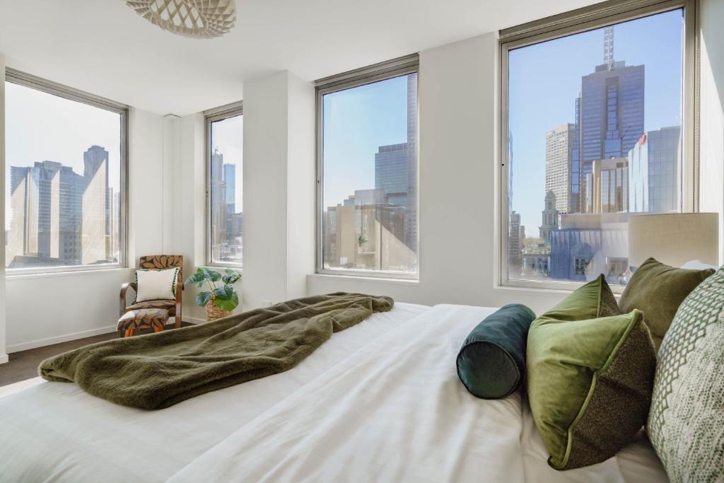 1 dormitorio con 1 cama blanca grande y ventanas en Urban Oasis on Collins en Melbourne