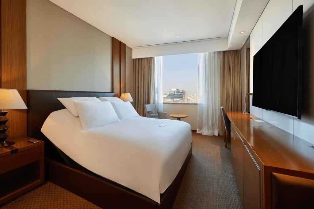 um quarto de hotel com uma cama grande e uma televisão em LOTTE City Hotel Guro em Seul