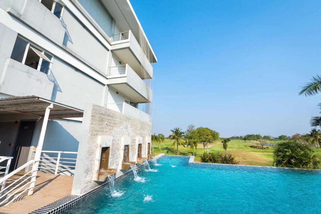 een zwembad voor een gebouw bij Uniland Golf & Resort in Nakhon Pathom