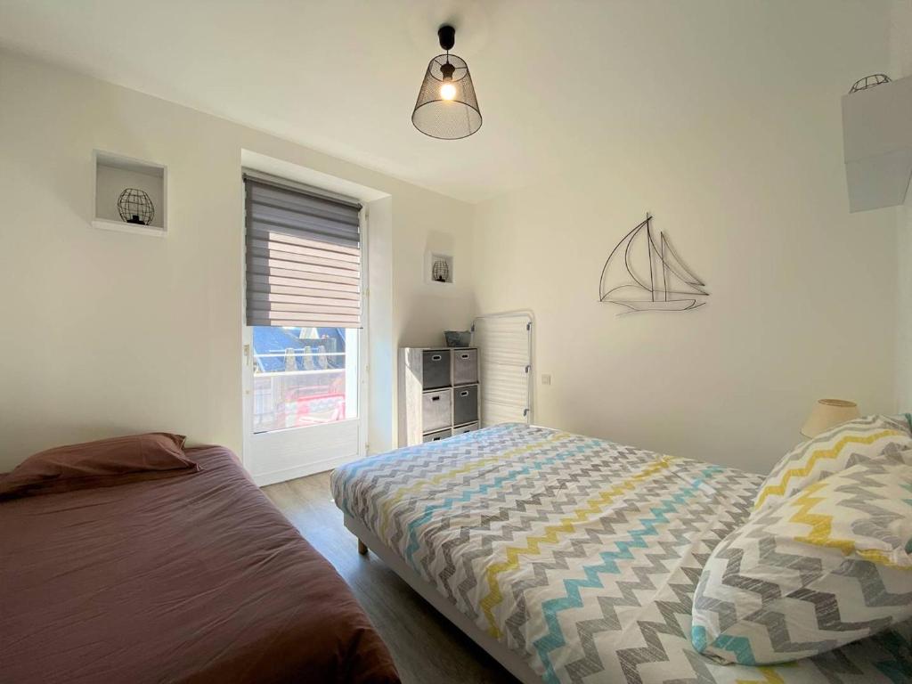 sypialnia z łóżkiem i oknem w obiekcie Appartement rénové 5 personnes avec balcon au centre de Perros-Guirec - FR-1-368-382 w mieście Perros-Guirec
