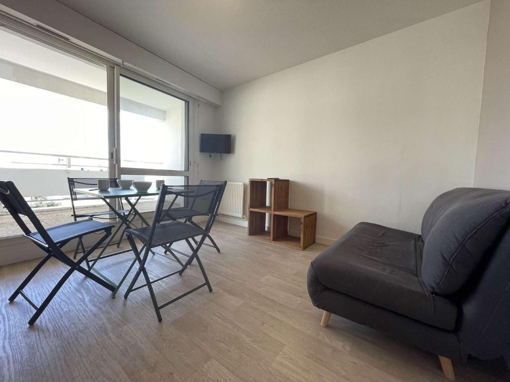 uma sala de estar com uma mesa e cadeiras e um sofá em Appartement La Rochelle, 2 pièces, 4 personnes - FR-1-246-653 em La Rochelle