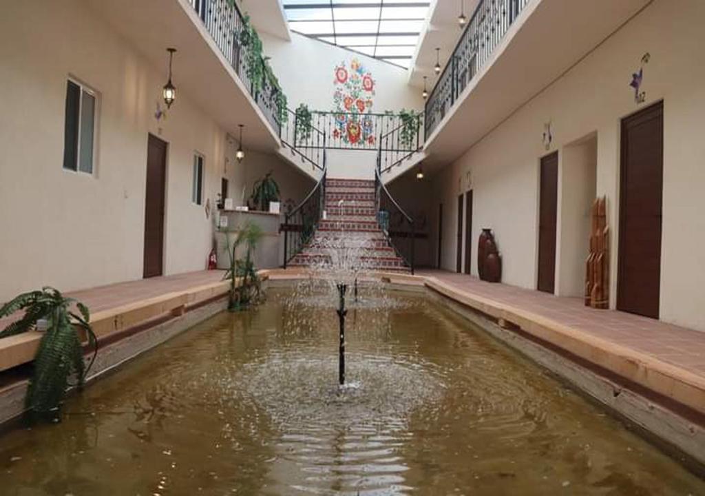 an empty room with a pool of water in a building at Mia Bonita Hotel Boutique in Tararameo