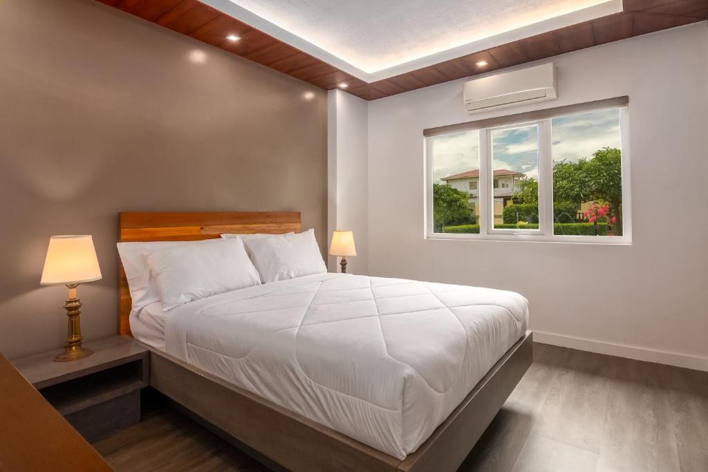 a bedroom with a white bed and a window at Amor Laut in Mabini