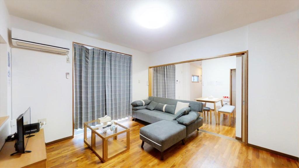 salon z kanapą i telewizorem w obiekcie Suminchu House Ichariba w mieście Naha