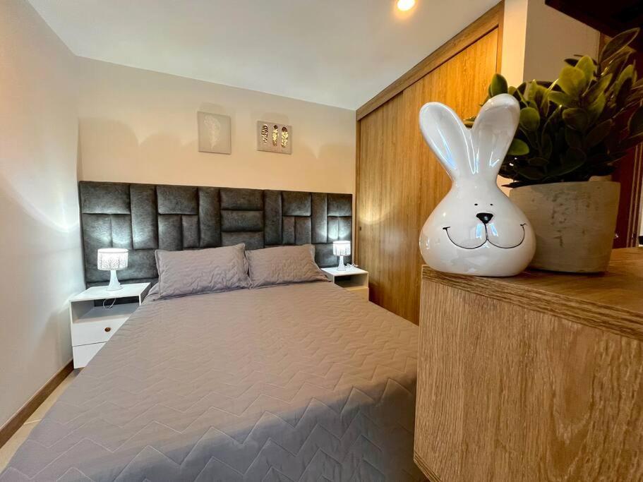 ein Schlafzimmer mit einem Bett mit einem Häschen Kopf drauf in der Unterkunft Espectacular vista cerca a cable plaza con Piscina in Manizales