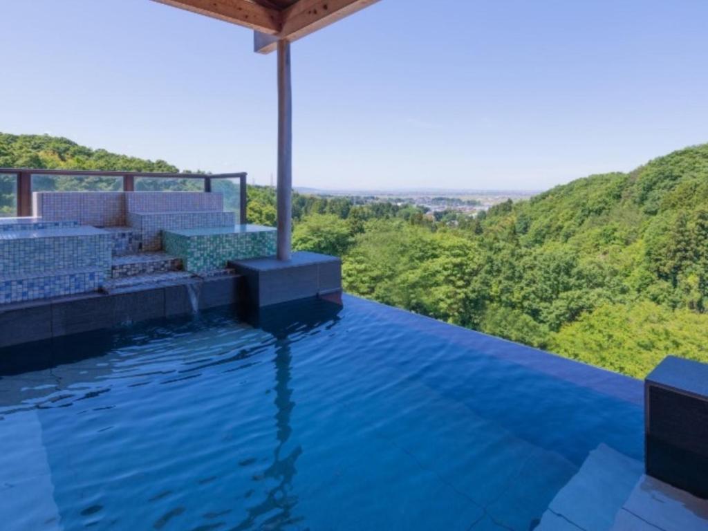 a swimming pool with a view of a mountain at Hotel Oyanagi in Tagami