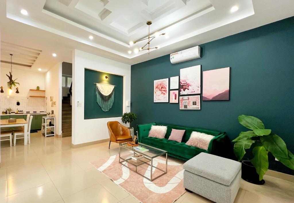 ein Wohnzimmer mit einem grünen Sofa und einem Tisch in der Unterkunft Contemporary Greenhouse Garden Villa- 4 bedrooms Villa in Vũng Tàu