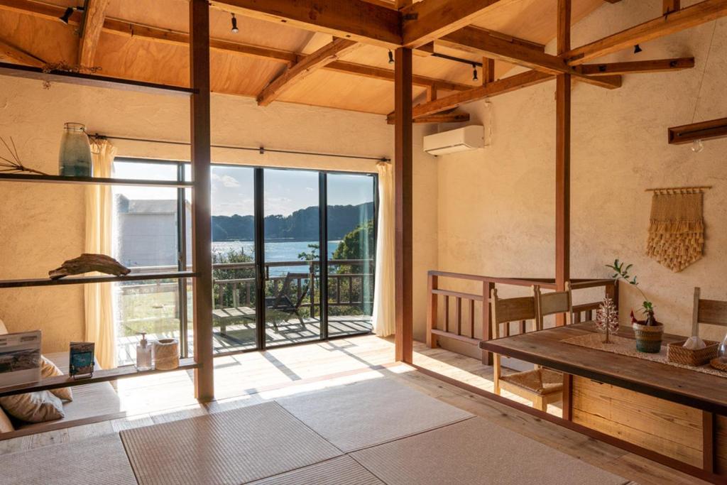a living room with a large window and a table at Villa Yumigahama in Minamiizu