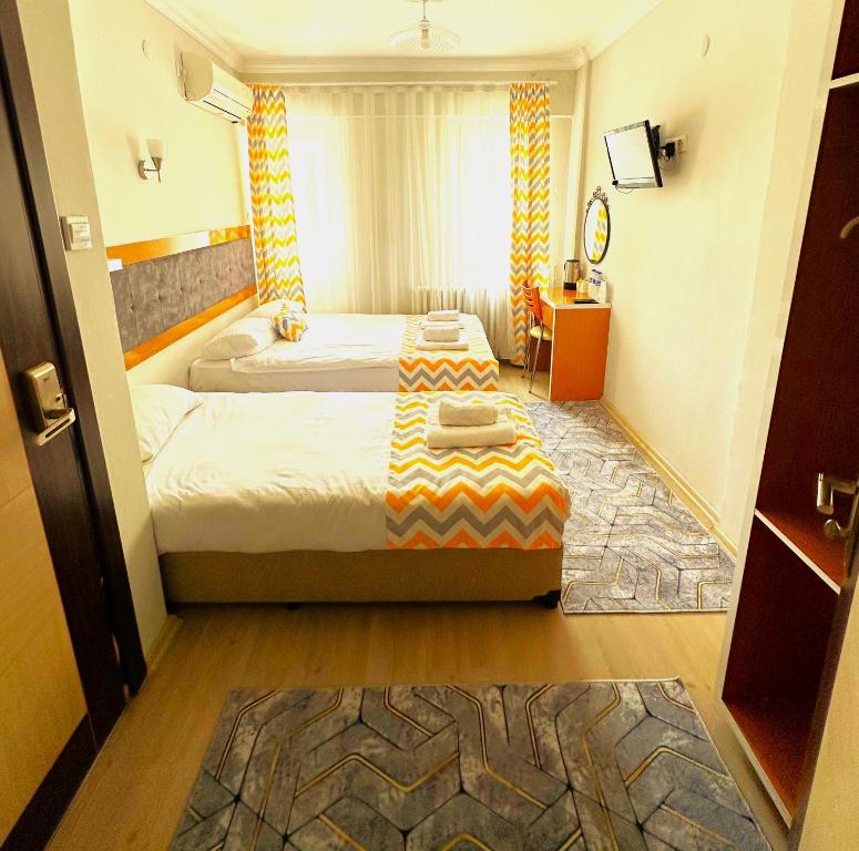 ein Hotelzimmer mit 2 Betten und einem Tisch in der Unterkunft Kestanbol Hotel in Canakkale