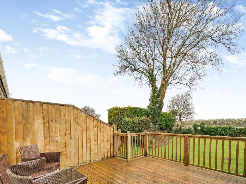 a wooden deck with chairs and a fence at Uk43576 - Bramble Cottage in Begelly